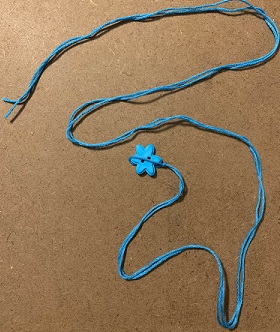 floss folded in half with loop around button