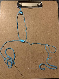 bracelet on clipboard with beads being strung on it