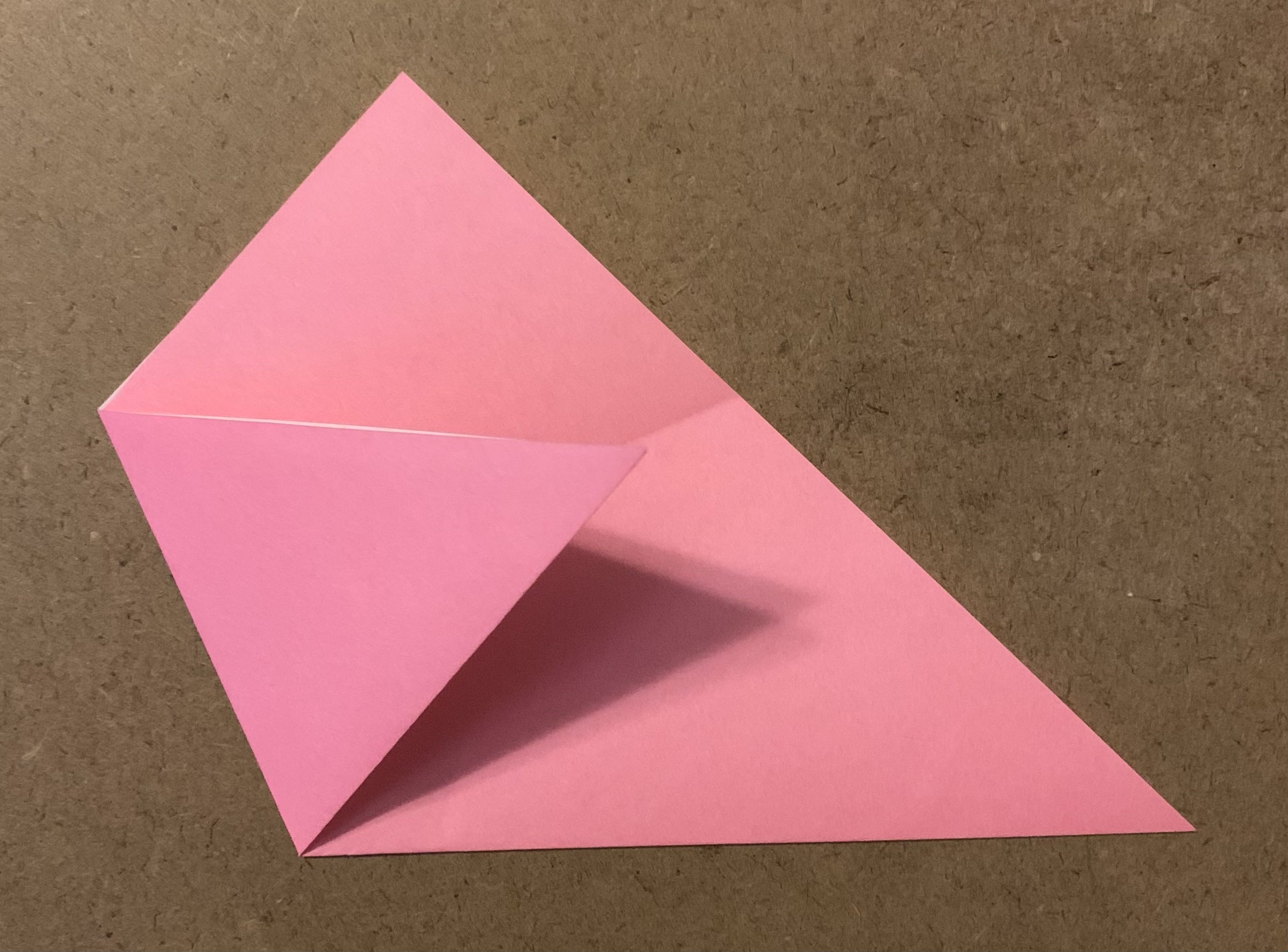 origami paper folded into triangle with left point folded across the top