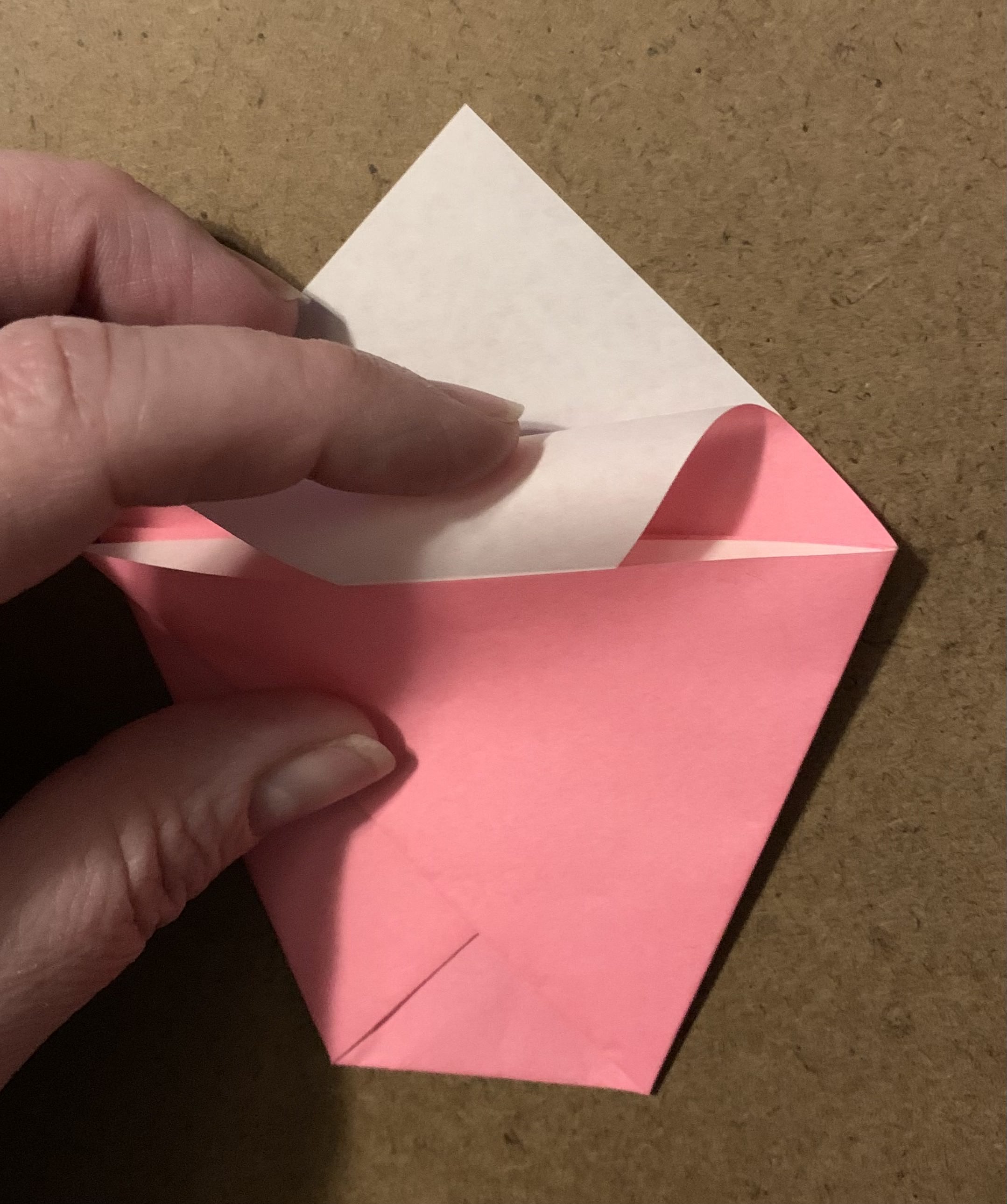 origami paper shape tucking front part of top point into the crossed left and right points